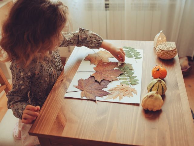 girl making art piece with leaves