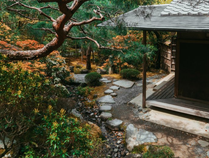 A Stone Garden Path Next To A Pavilion