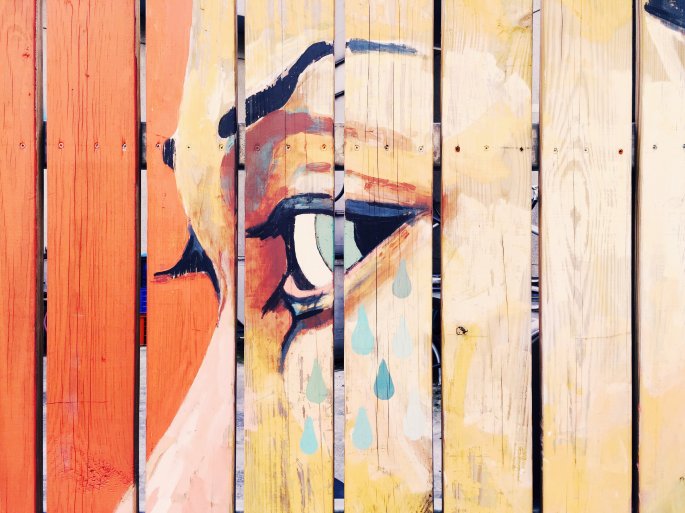 A Fence Painting Of A Woman Crying