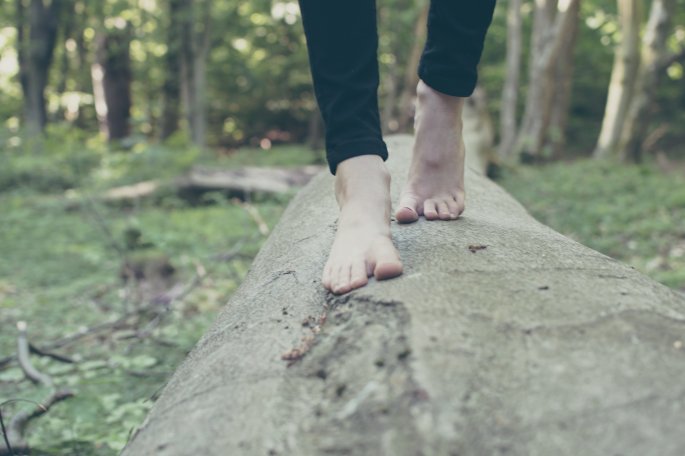 Bare Feet Walking Along A Log