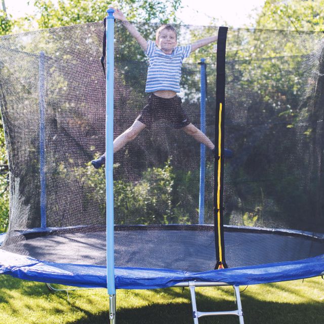 Little Boy Jumping On Trampoline